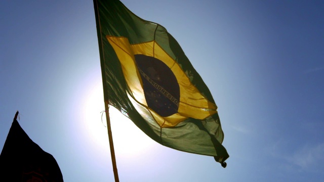 破旧的巴西国旗在慢镜头中摇曳，阳光透过视频素材