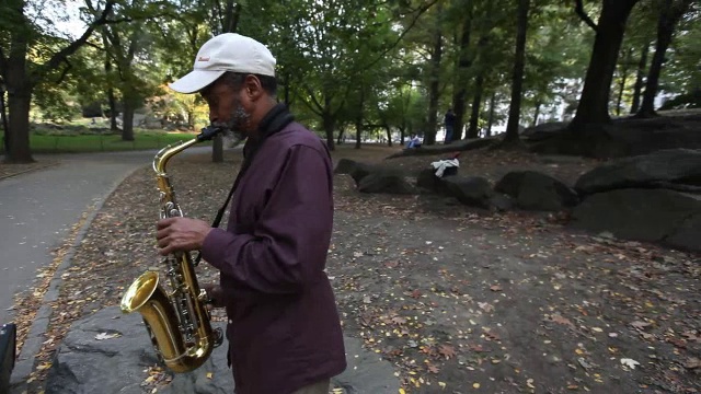 一位老人在纽约市公园吹萨克斯风视频素材