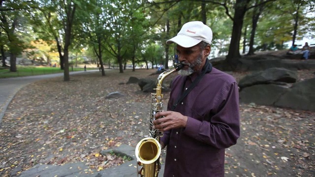 老街头音乐家演奏萨克斯风在纽约市公园的情况开放小费视频素材