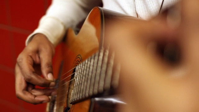 街头音乐家在城市地铁站熟练地用手指挑选原声吉他视频素材