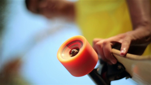 巴西少年手持滑板，轮子还在旋转视频素材