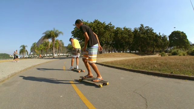巴西少年在滑板上奔跑跳跃，以慢镜头追上朋友视频素材