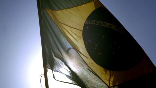 破旧的巴西国旗在慢镜头中摇曳，阳光透过视频素材