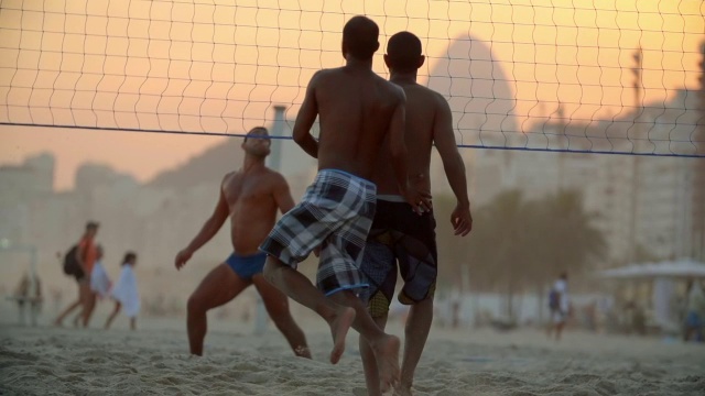 在科帕卡巴纳海滩上，足球凌空队员跃起头球越过网视频下载