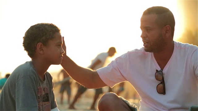 父亲在阳光明媚的巴西海滩上给儿子讲课视频素材