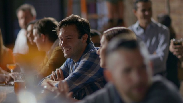 女人让男人在拥挤的酒吧里开怀大笑视频素材