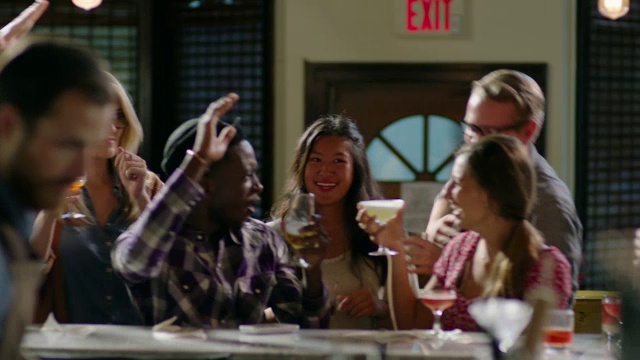 一群朋友在酒吧跳舞，酒保斟酒视频素材
