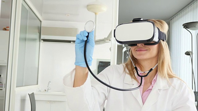 拥有虚拟现实模拟器和听诊器的年轻医生视频素材
