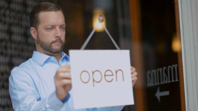 小企业主在门上挂“开门”的牌子视频素材
