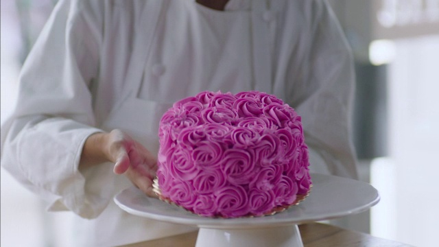 糕点师将蛋糕放在托盘上，并用糖衣袋装饰视频素材