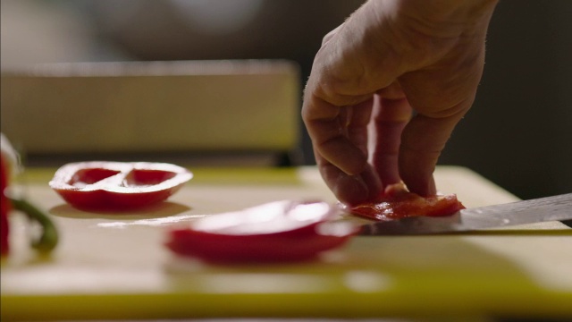 在餐厅厨房里，熟练的工人切红辣椒时，果汁喷溅视频素材