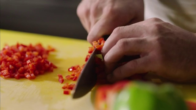 厨师的手在餐厅厨房将红辣椒切碎视频素材