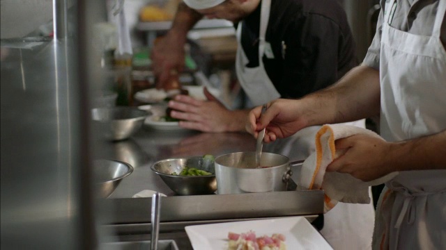 在繁忙的厨房餐厅，美食厨师将热气腾腾的龙虾放在扇贝上视频素材