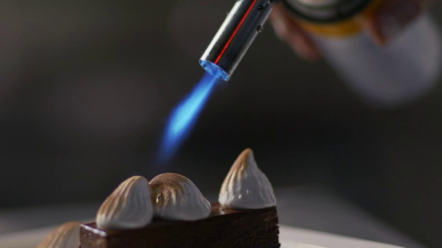 餐厅糕点师用厨房喷灯烤棉花糖奶油。视频下载