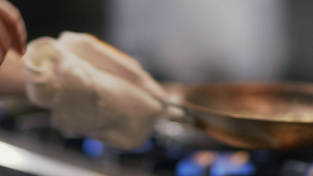 餐厅厨师在餐厅厨房里把蔬菜在燃烧的煎锅里翻动视频素材
