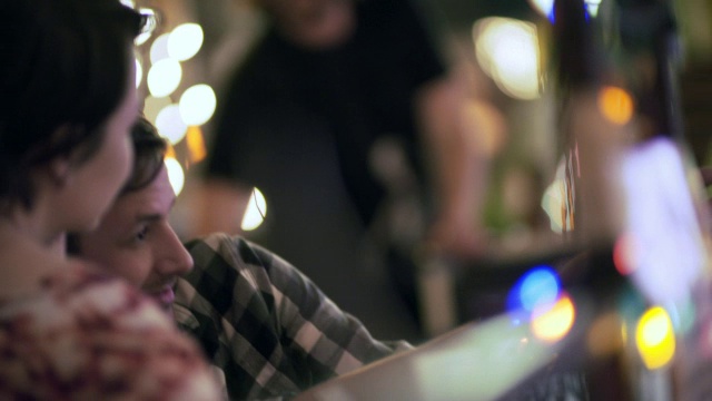 一对年轻夫妇在五颜六色的奥斯汀酒吧里用智能手机自拍视频素材