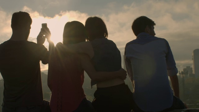 一群朋友互相拥抱，用智能手机拍照，俯瞰德克萨斯州奥斯汀市的天际线视频素材