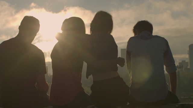 一群朋友在城市的天际线上互相拥抱，用智能手机拍照视频素材