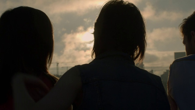 两个年轻女子拥抱着俯瞰城市的天际线视频素材