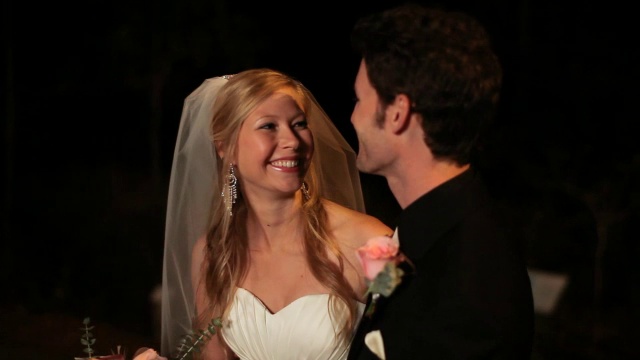 手持式近距离新娘和新郎亲吻和姿势，而相机闪光灯在户外在晚上视频素材