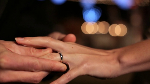 手持式镜头:当照相机闪光时，新郎的手把结婚戒指戴在新娘的手指上视频下载