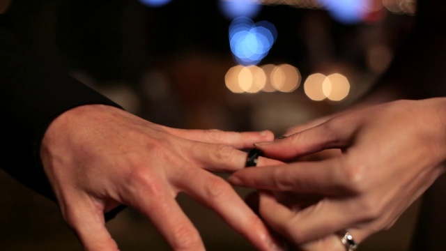 手持式特写新娘的手把结婚戒指戴在新郎的手指上视频素材
