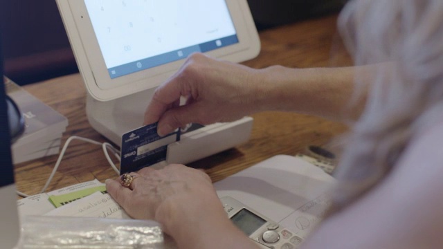 收银员在收银台用平板电脑刷信用卡视频下载