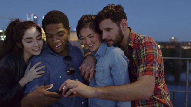 一群朋友聚集在人行天桥上的智能手机旁视频素材