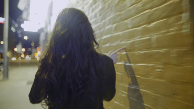一名年轻女子的手在德克萨斯州奥斯汀市中心的壁画上摸来摸去视频下载