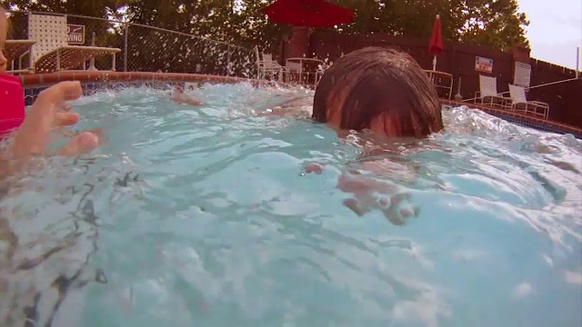 小游泳者的父亲潜入水中吹泡泡视频素材