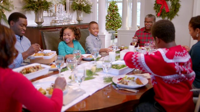 家人在餐桌上传递盘子准备圣诞晚餐视频素材