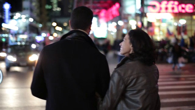 一对纽约夫妇穿过繁忙的街道，停在时代广场的灯光下亲吻过往的汽车视频素材