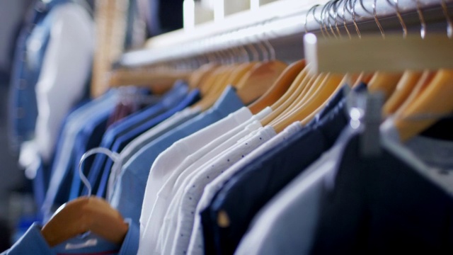 在现代服装店，顾客把衬衫挂在衣架上视频下载