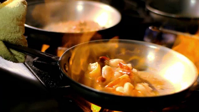 火在炉子上加热盛满虾的平底锅。视频素材