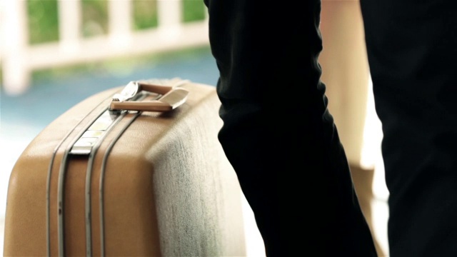 男人放下行李箱，跳上汽车旅馆的床视频素材
