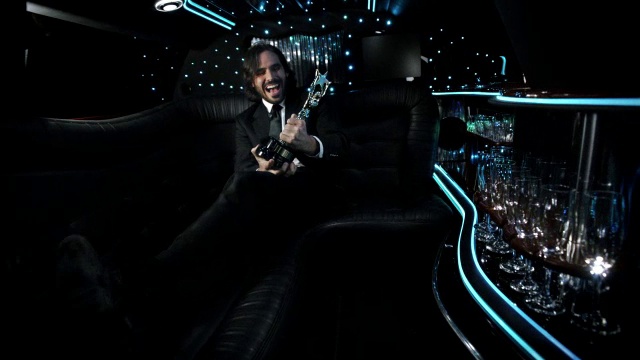 颁奖典礼上，当明星在豪华轿车后座拿着奖杯欢呼时，照相机闪烁视频素材