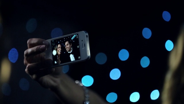 好莱坞夫妇在豪华轿车里用智能手机拍照视频素材