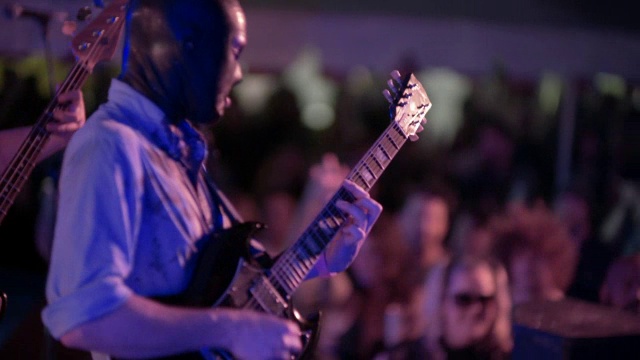 在户外音乐节上，蒙面人与摇滚乐队一起弹奏吉他视频下载