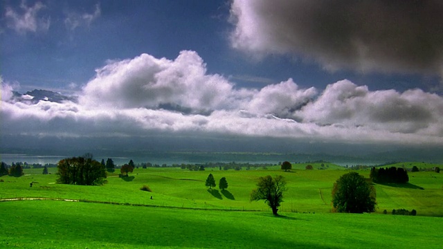 宽镜头延时云移动低在绿色山谷/湖泊和山脉的背景/巴伐利亚，德国视频下载
