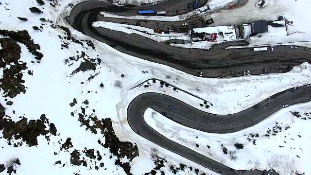 无人机在比利牛斯山脉上空拍摄的航拍镜头，上面有雪景和美丽的曲线，汽车在比利牛斯山脉上行驶。4 k UHD。视频下载