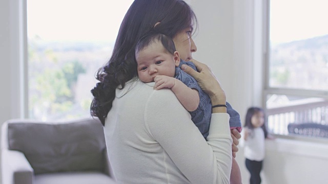 少数民族母亲抱着新生儿和女婴的背景视频素材