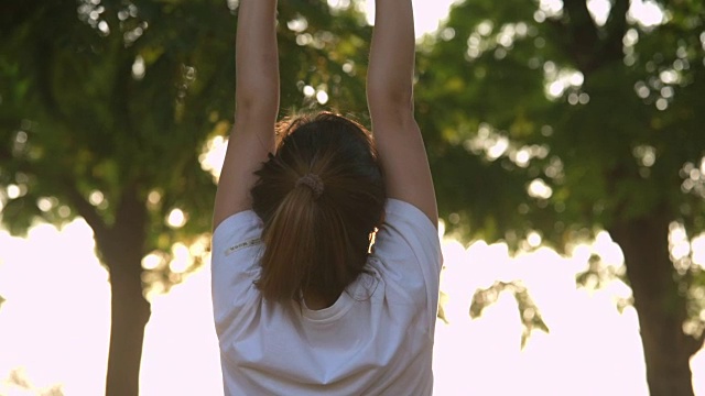 运动亚洲女人伸展在公共公园视频下载