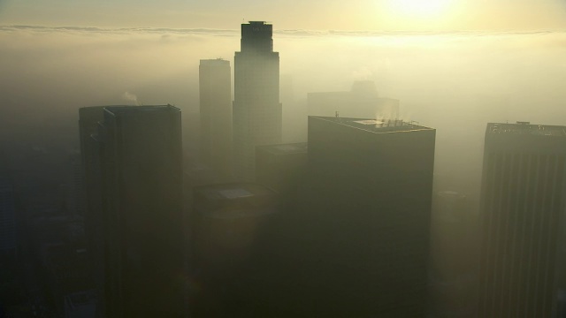 洛杉矶市中心摩天大楼的鸟瞰图，被金色的雾霾包围。视频素材