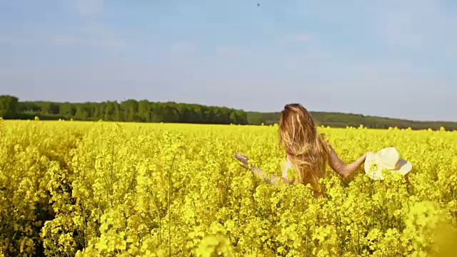 女人在盛开的菜籽油中奔跑视频素材