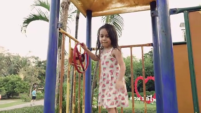 一个小女孩在公园里滑滑梯视频素材
