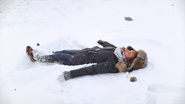 年轻女子做雪天使视频素材