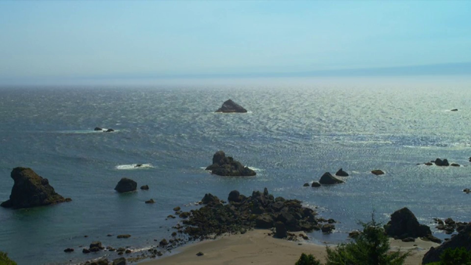 高角度广角拍摄的海滩和海洋的岩石带大卵石在早上，红木国家公园，加州视频下载