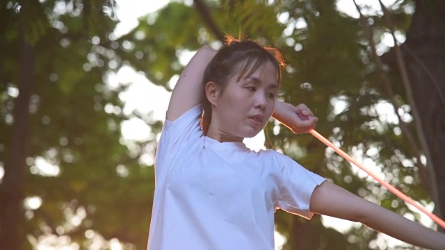 运动亚洲女人伸展在公共公园视频素材