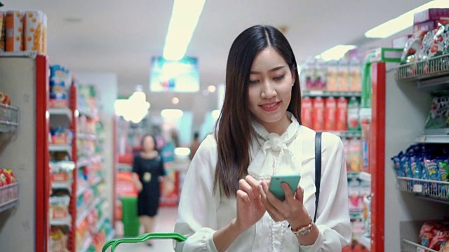 女人在超市用智能手机，慢镜头视频下载