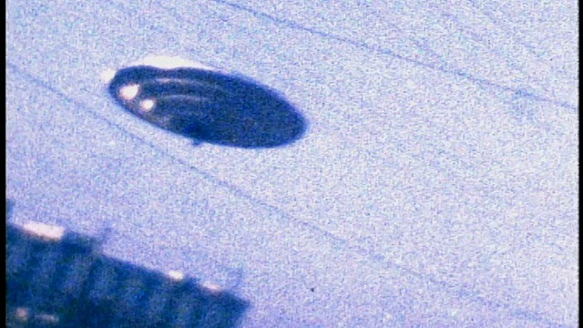 慢镜头低角度UFO盘旋在建筑物上方视频下载